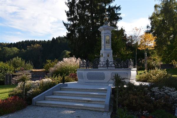 Ein steinernes Denkmal mit einer Statue inmitten eines Parks